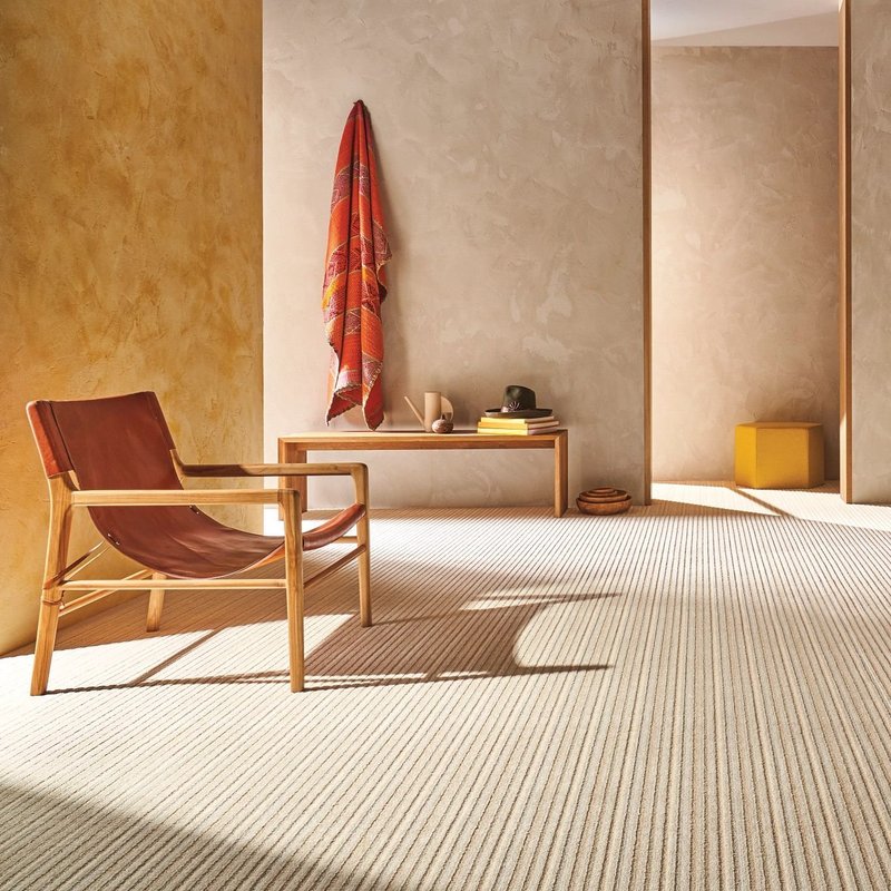 Red chair in a warm living space with a beige carpet from Wilmington Carpets in the Wilmington, OH area